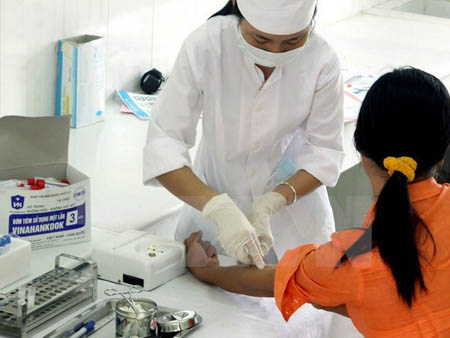 Cán bộ y tế của Trung tâm Phòng chống HIV/AIDS tỉnh Ninh Bình lấy mẫu máu xét nghiệm HIV/AIDS cho khách hàng.